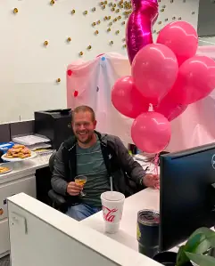 An employee in an office cubicle celebrating a personal milestone